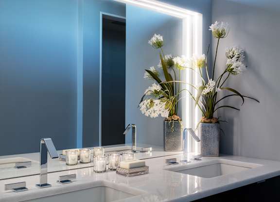 A modern bathroom with a white sink and a large mirror at Residences Providence, Rhode Island 2903