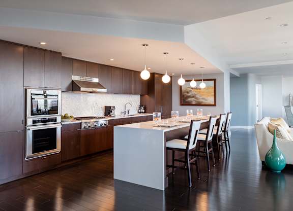 A modern kitchen with a long island and chairs at Residences Providence, Providence