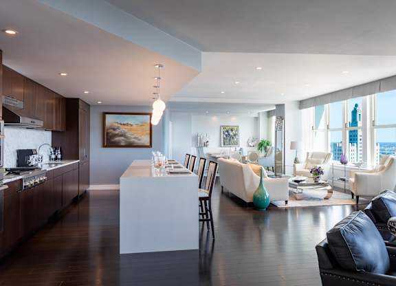 A modern kitchen with dark wood floors and a large island in the middle at Residences Providence, Rhode Island