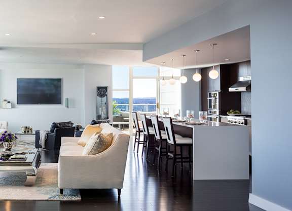 A modern living room with a large window overlooking the water at Residences Providence, Providence, Rhode Island