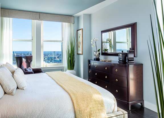 A bedroom with a large bed and a view of the city at Residences Providence, Providence, RI 2903