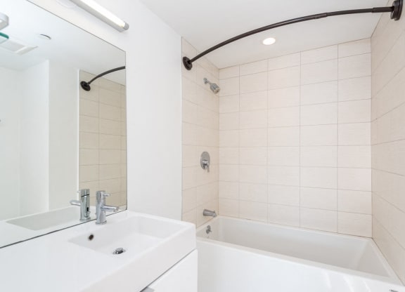 a bathroom with a sink and a tub and a mirror