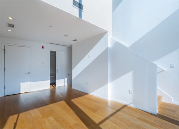 a living room with white walls and wooden floors