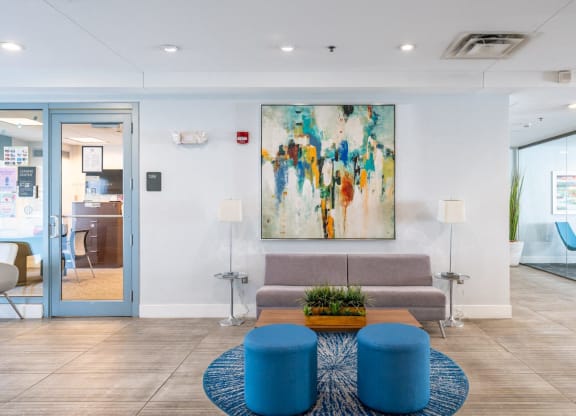 50 WB's leasing office lobby with a couch and a coffee table and a painting on the wall