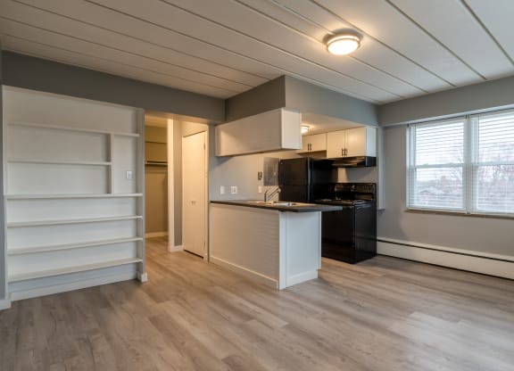 a kitchen with a island and a black stove and a refrigerator