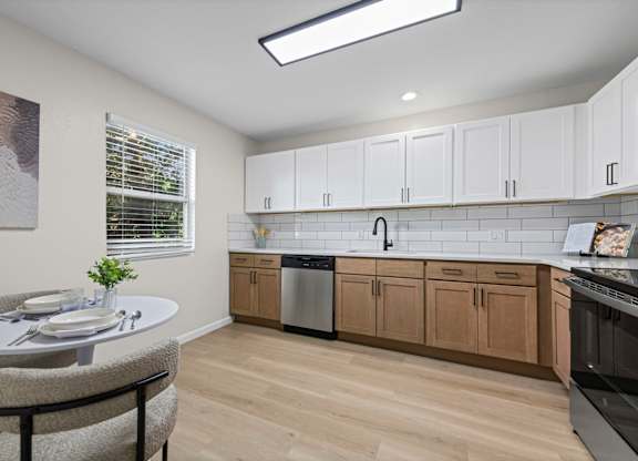A kitchen with a table and chairs and a window.