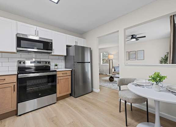 A modern kitchen with a dining table set for two.