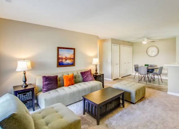 A living room with a couch, chairs, and a coffee table.