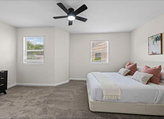 A bedroom with a bed, dresser, and window.