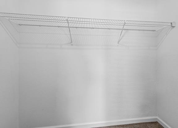Empty wire shelving unit in a white room.