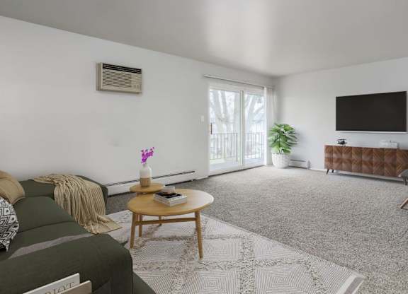 A living room with a green couch, a coffee table, and a flat-screen TV.