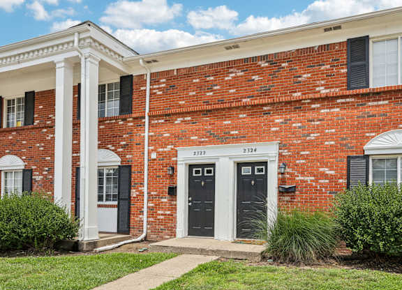 A red brick building with a white door and windows.