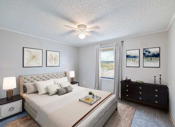 A bedroom with a large bed, a dresser, and a ceiling fan.