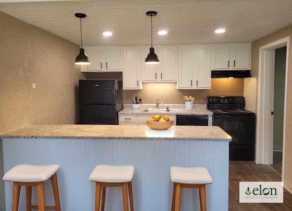 A kitchen with a counter and bar stools.