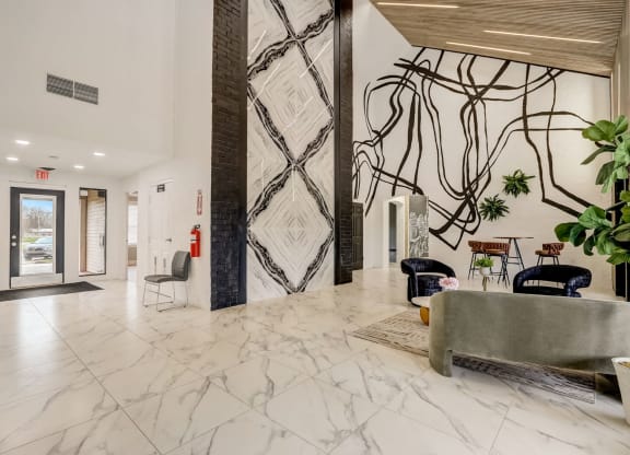 a lobby with marble flooring and a wall with a black and white wallpaper