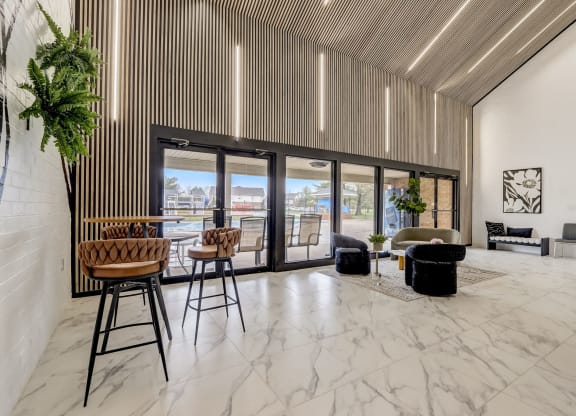 a living room with marble flooring and a table with high chairs