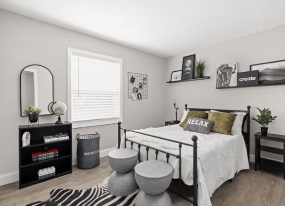 a bedroom with a zebra rug and a bed with a white comforter and pill