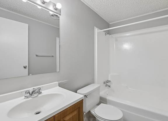 A white bathroom with a sink, toilet, and bathtub.