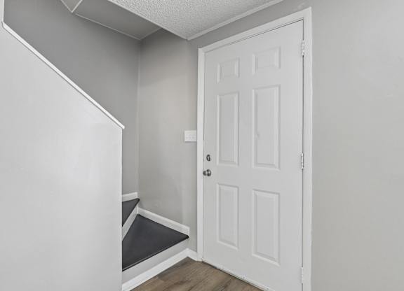 A white door is in a room with white walls.