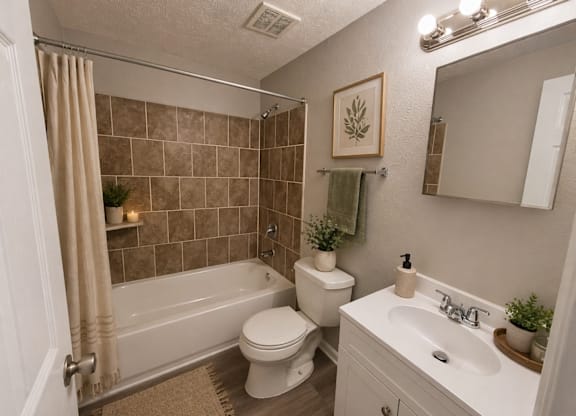 A bathroom with a toilet, sink, and bathtub.