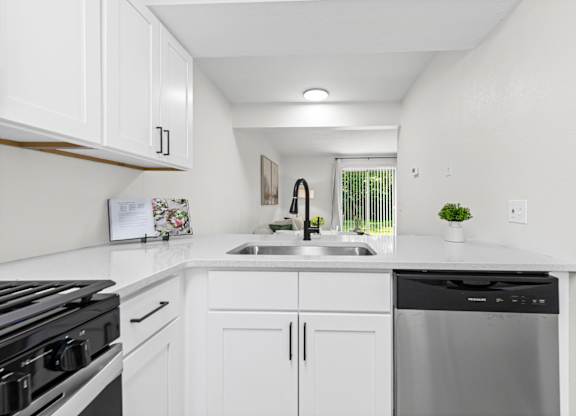 A kitchen with white cabinets and a black stove top.