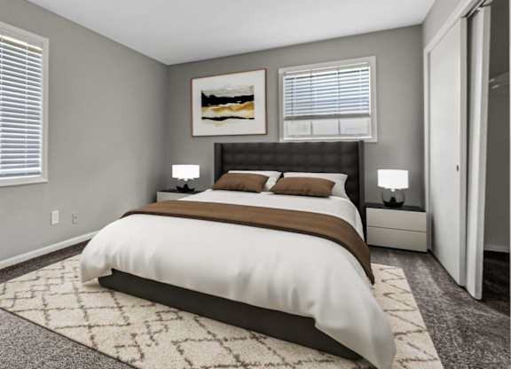 A bedroom with a large bed and a rug on the floor.