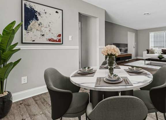 A dining room with a round table and chairs.
