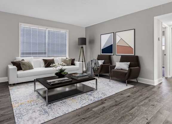 A living room with a white couch, a coffee table, and a rug.