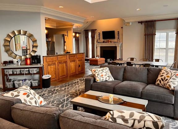 A living room with a grey couch and a wooden cabinet.