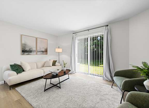 A living room with a white couch, a coffee table, and a painting on the wall.