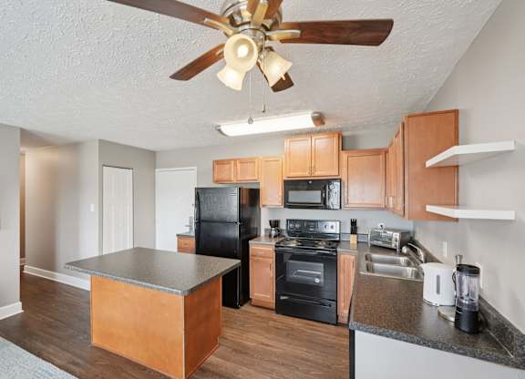 A kitchen with wooden cabinets and black appliances.