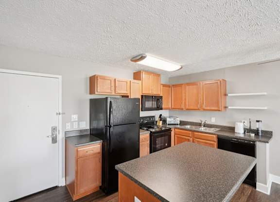 A kitchen with black appliances and wooden cabinets.
