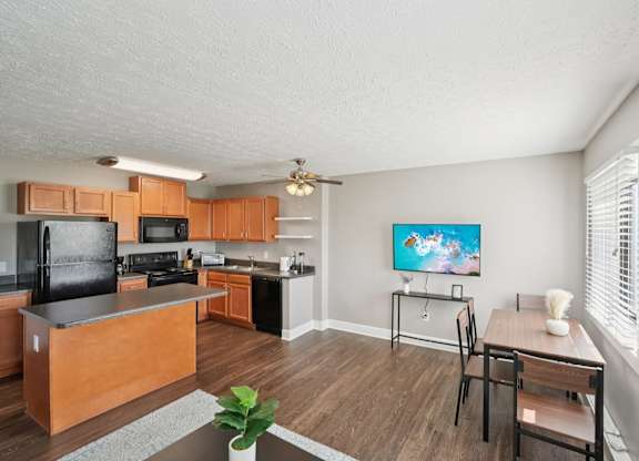 A kitchen with a black fridge and a black stove top oven.