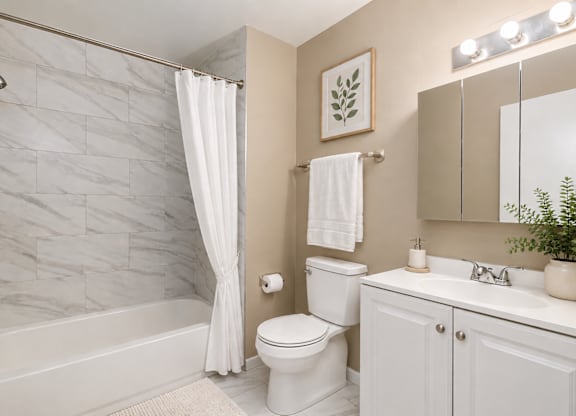 A white bathroom with a marble tile shower.
