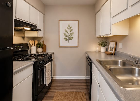 A kitchen with a black stove top oven and white cabinets.