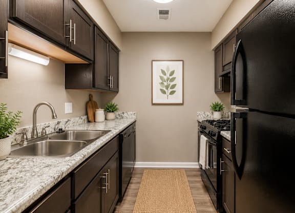A kitchen with black cabinets and a black refrigerator.
