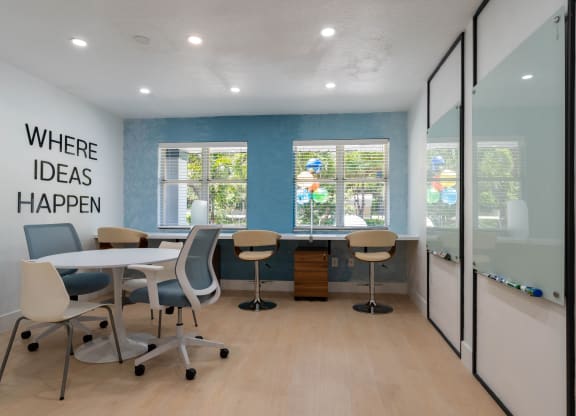 a conference room with a table and chairs and a window at Aqua Bay Apartments in Naples, FL 34116