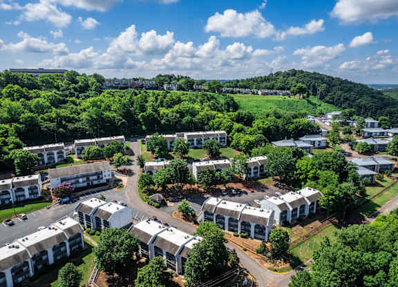 A bird's eye view of a residential complex surrounded by greenery.