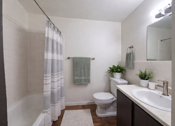 A white toilet sits next to a white sink in a small bathroom.