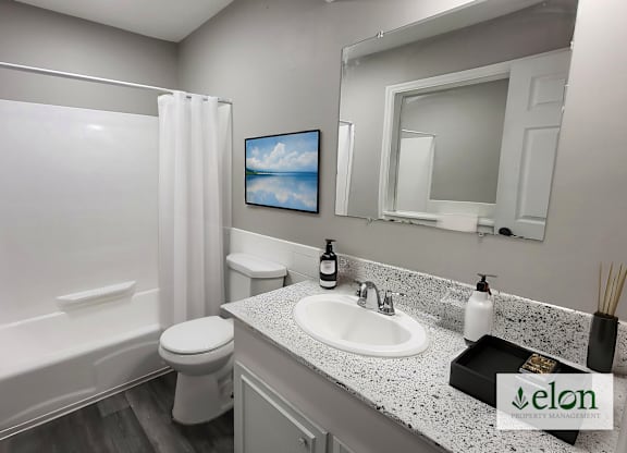 A bathroom with a white toilet, sink, and bathtub.