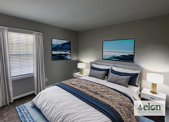 A bedroom with a bed, two lamps, and two pictures on the wall.