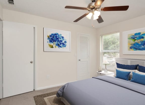 A bedroom with a bed and a ceiling fan at Aqua Bay Apartments in Naples, FL 34116