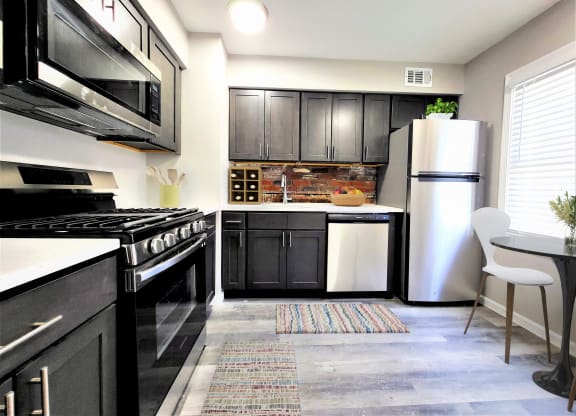 a kitchen with black cabinets and white appliances
