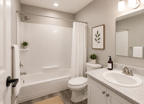 A bathroom with a white tub, sink, and toilet.