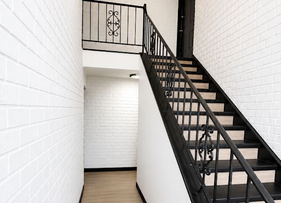 A black and white staircase with a wooden floor.