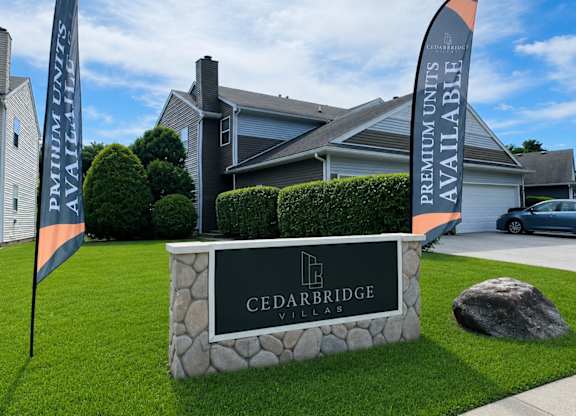A sign for Cedarbridge Villas in front of a house.