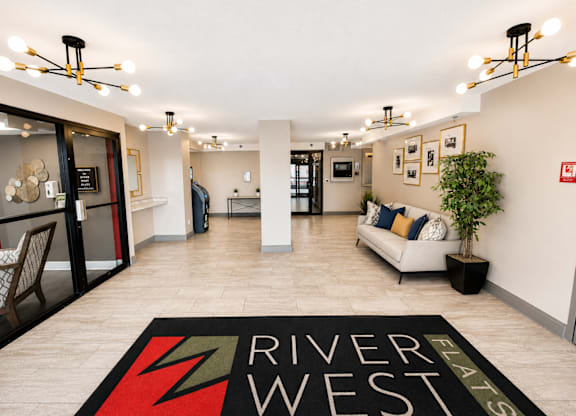 A living room with a rug that says River West.