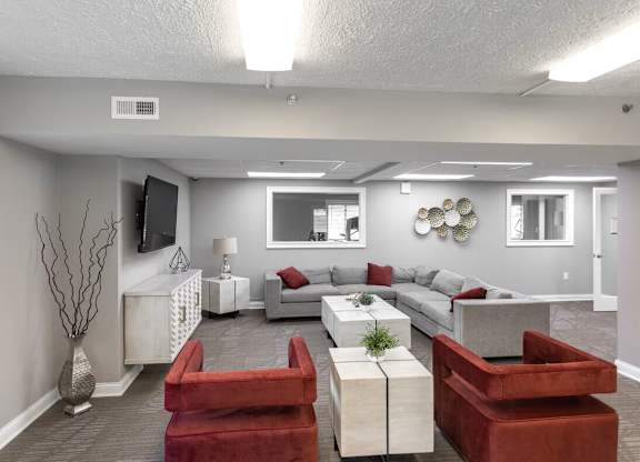 A living room with a red couch and a white coffee table.