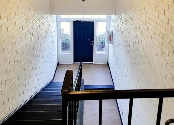 A white brick wall with a light hanging from the ceiling.