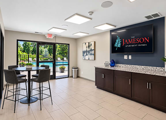 A modern office space with a bar area and a view of the outdoors.